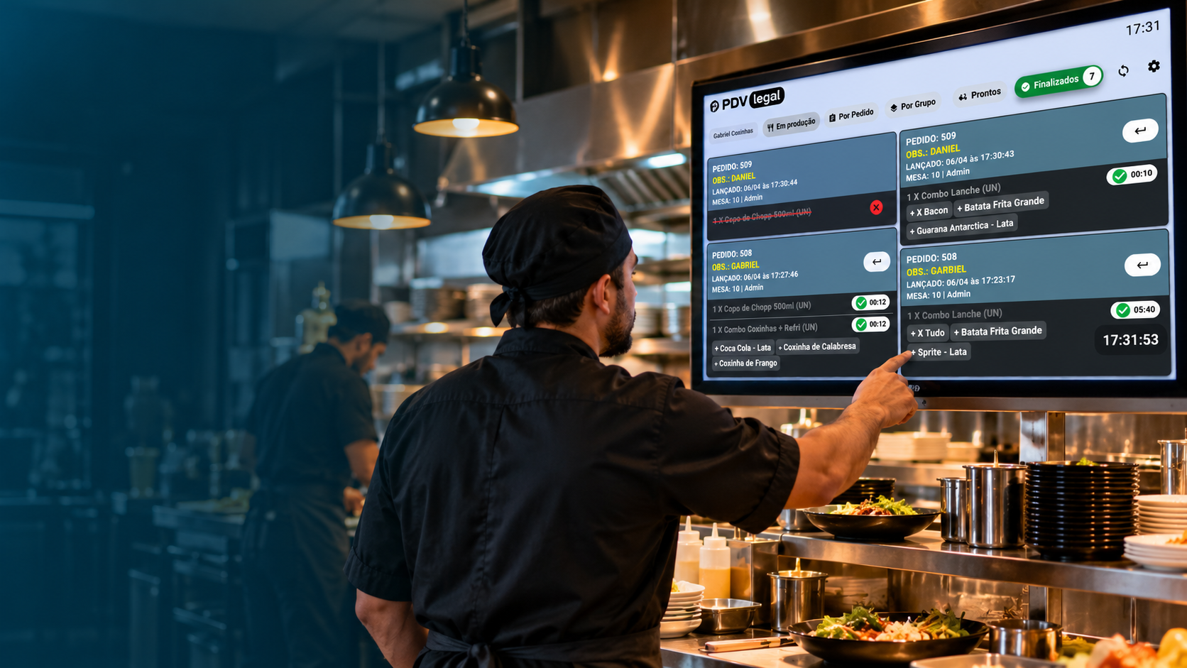 Cozinheiro acompanhando pedidos em uma tela KDS na cozinha de restaurante